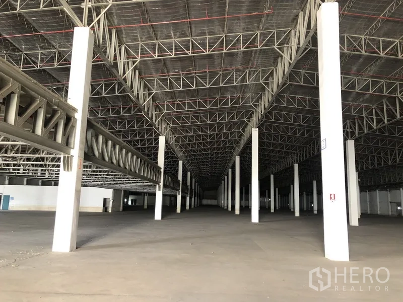 Warehouse for rent in Lam Luk Ka, Pathum Thani - Long central aisle of warehouse showing multiple columns and wide open storage floor