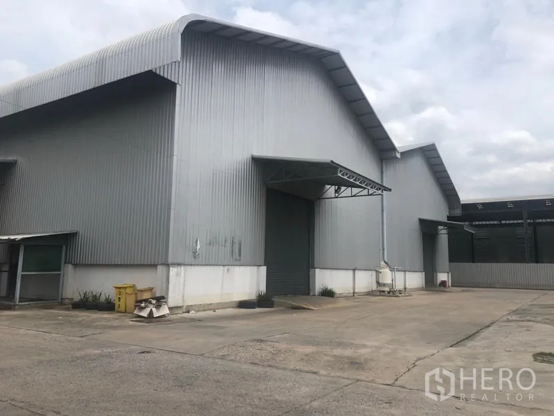 Factory for rent in Khlong Luang, Pathum Thani - Steel-clad factory exterior with high gable roof, loading bay and wide driveway in Khlong Luang.