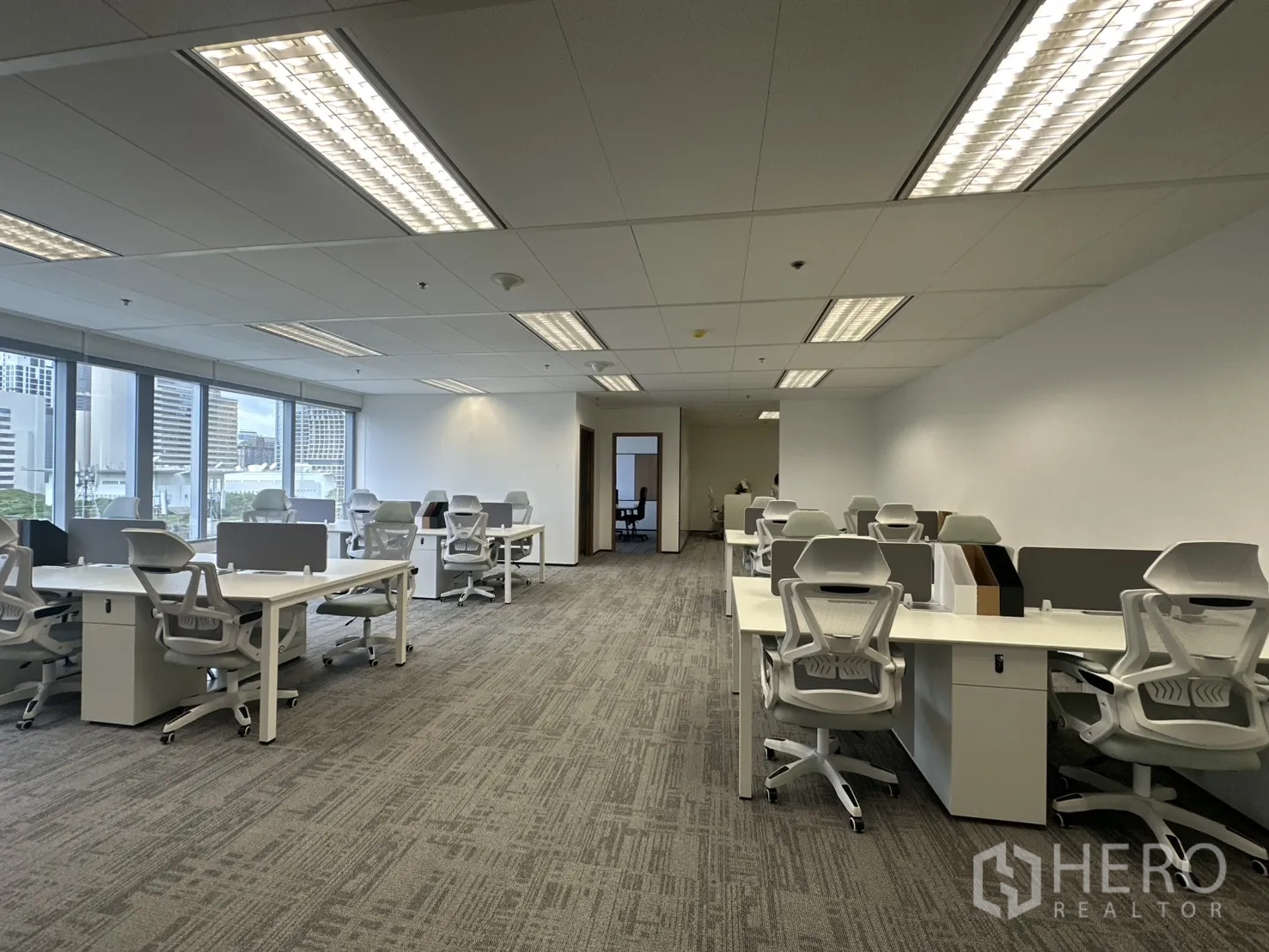 Office Space for rent in Pathum Wan, Bangkok - Spacious workspace with ergonomic chairs under fluorescent lighting.