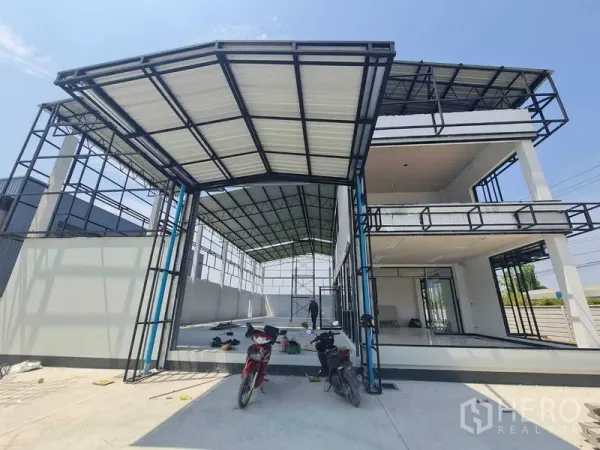 货栈 出租在Bang Len, Nakhon Pathom - 仓库正面：高净空装卸雨棚与采光良好的两层玻璃办公区并排。
