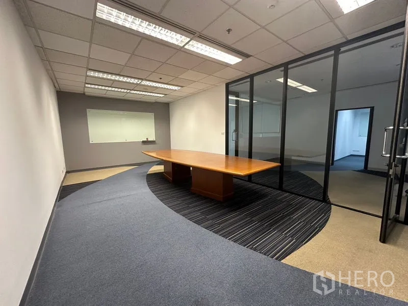 Office Space for rent in Khlong Toei, Bangkok - Boardroom with a long wooden conference table behind floor-to-ceiling glass.