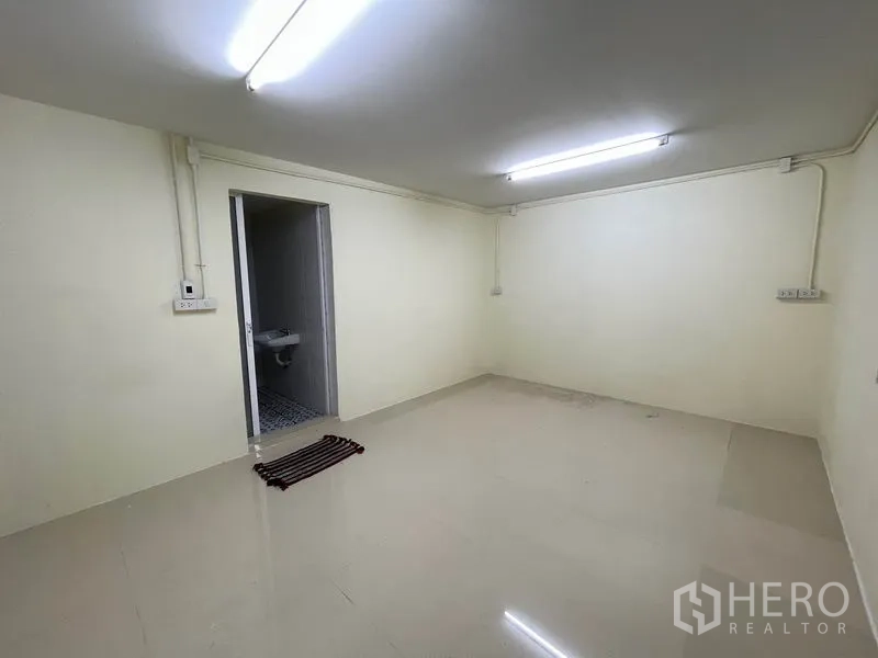 Warehouse for rent in Khlong Luang, Pathum Thani - Well-lit office space with power outlets and access to bathroom.