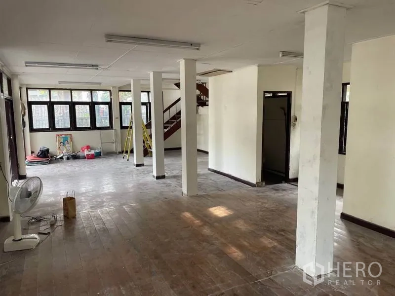 Detached House for rent in Suan Luang, Bangkok - Open-plan living space with columns and a staircase at the rear.