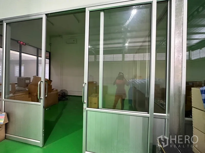 Factory for rent or sale in Lam Luk Ka, Pathum Thani - Sliding glass doors to an enclosed packing or QC room inside the warehouse.