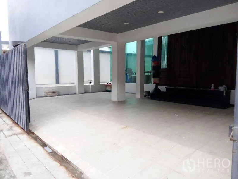 Detached House for sale in Lat Phrao, Bangkok - Covered parking area behind sliding gate with space for multiple cars.