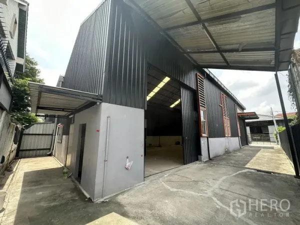 Warehouse for rent in Lat Phrao, Bangkok - Main warehouse entrance with tall sliding door, sheltered loading bay and concrete yard.