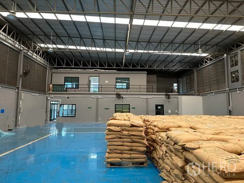 Factory for rent in Samut Prakan - View of high-clear warehouse with mezzanine offices and ventilation panels.