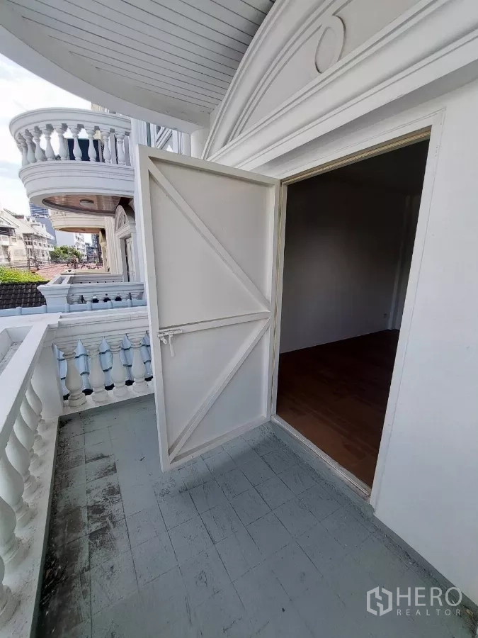 Home Office for rent in Yan Nawa, Bangkok - Balcony with classic balustrades and arched facade overlooking the neighborhood.