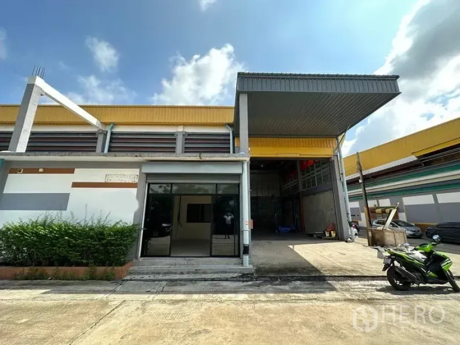 Warehouse for rent in Khlong Luang, Pathum Thani - Modern warehouse exterior with covered loading bay, roller shutter and parking in Khlong Luang.