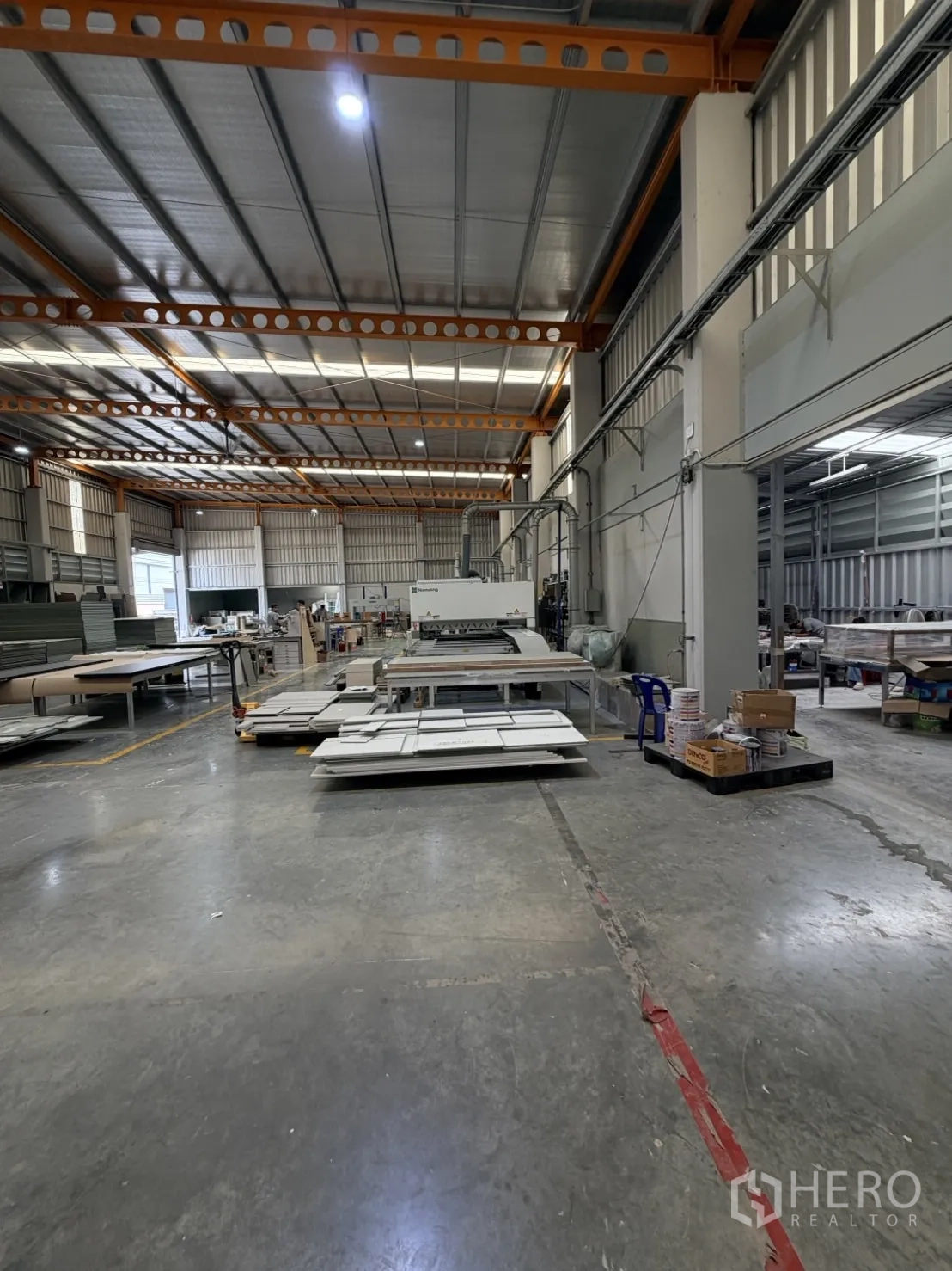 Factory for rent or sale in Lam Luk Ka, Pathum Thani - Production floor with industrial machines, panels, and marked walkways.