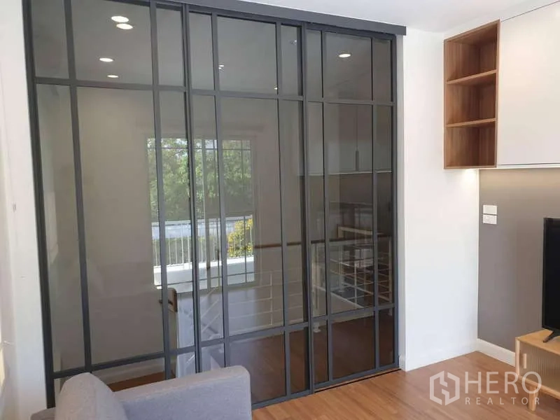 Detached House for rent in Sathon, Bangkok - Upstairs room featuring full-height sliding glass partition and warm wood flooring.