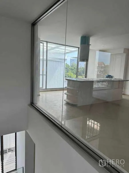Home Office for rent or sale - Bright kitchen with an island and range hood viewed through interior glazing.