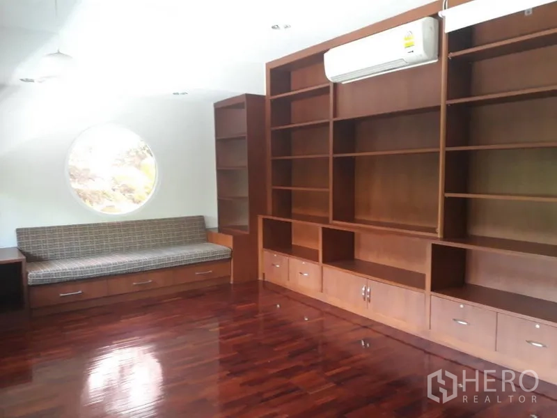 Detached House for rent in Watthana, Bangkok - Library or family room with floor-to-ceiling wooden shelves, built-in bench and circular window