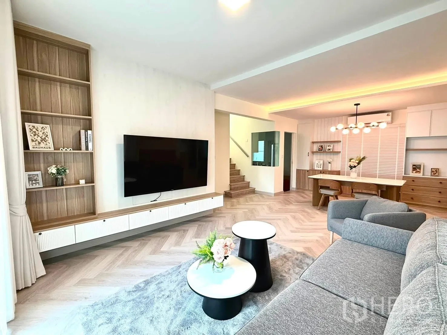 บ้านเดี่ยว for rent in Bang Phli, Samut Prakan - ห้องนั่งเล่นเปิดโล่ง โซฟาสีเทา ผนังทีวี ชั้นวาง และบันได.