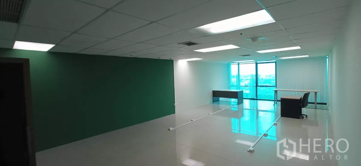 Office Space for rent in Huai Khwang, Bangkok - Open-plan 90 sqm office with green accent wall, drop ceiling lights and full-height windows in Huai Khwang.