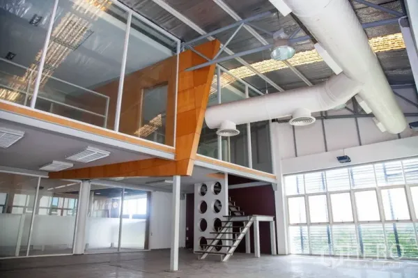 Warehouse for rent in Prawet, Bangkok - Glass-walled mezzanine office with metal staircase, large windows and white air ducts inside a Bangkok industrial warehouse.