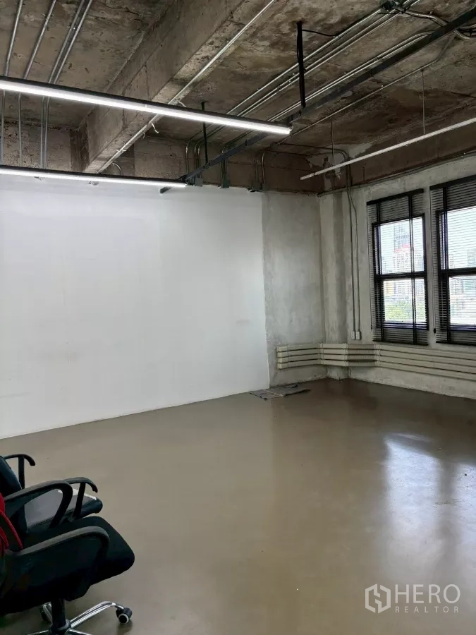 办公空间 出租在Watthana, Bangkok - 工作区设大窗与白色墙面，悬挂式线性LED灯具。