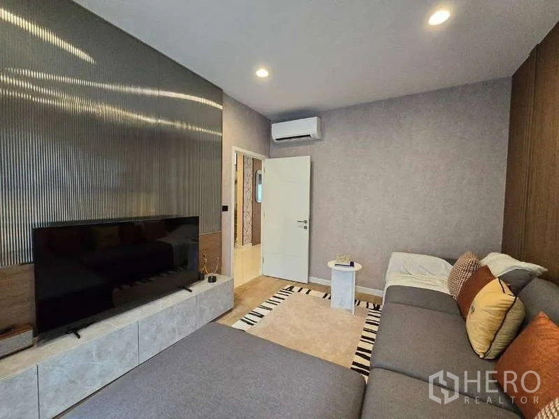 Detached House for rent in Bang Kapi, Bangkok - TV lounge alternate view showing media wall and air conditioning.