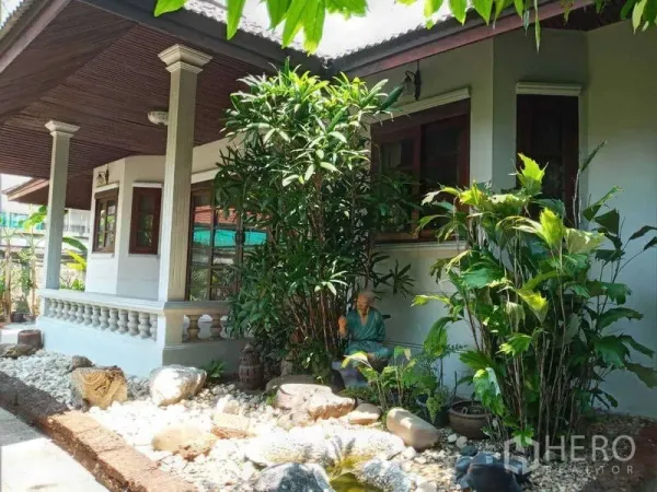 บ้าน ให้เช่าในKhlong Toei, Bangkok - ระเบียงบ้านร่มเงาพร้อมหน้าต่างไม้ สวนหิน และต้นไม้เขตร้อนหนาแน่น