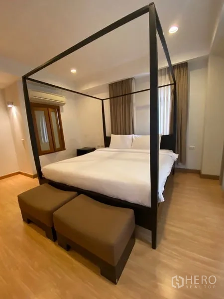 Condominium for rent in Watthana, Bangkok - Alternate view of the master bedroom highlighting the four-poster bed and airy windows.