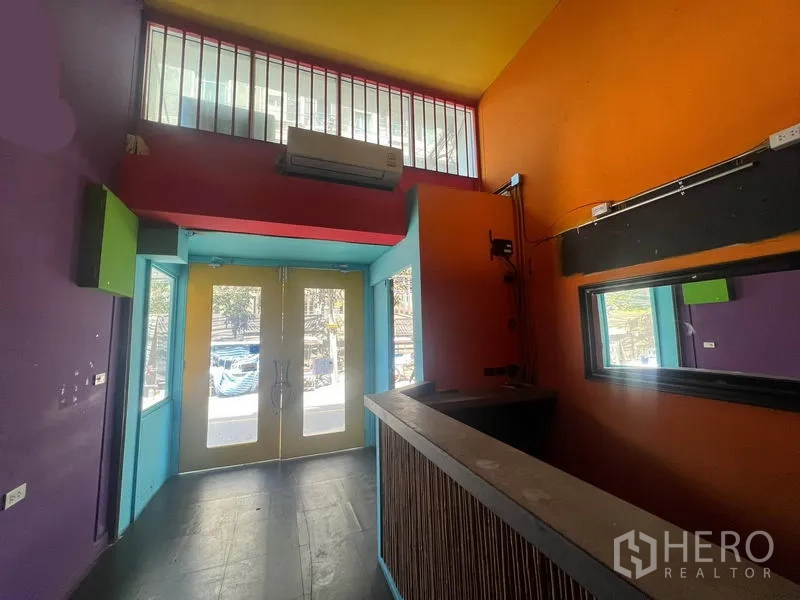 Shophouse for rent in Khlong Toei, Bangkok - Colorful entrance lobby with double glass doors, high ceiling and a small reception counter.