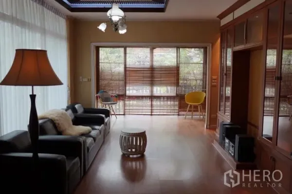 Detached House for rent in Suan Luang, Bangkok - Bright living room with leather sofas, wood flooring, bamboo blinds and built-in cabinets.