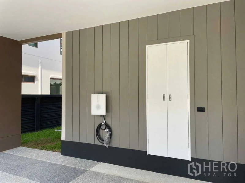 Detached House for rent in Bang Kapi, Bangkok - Covered carport equipped with an EV charging point and storage cabinet.