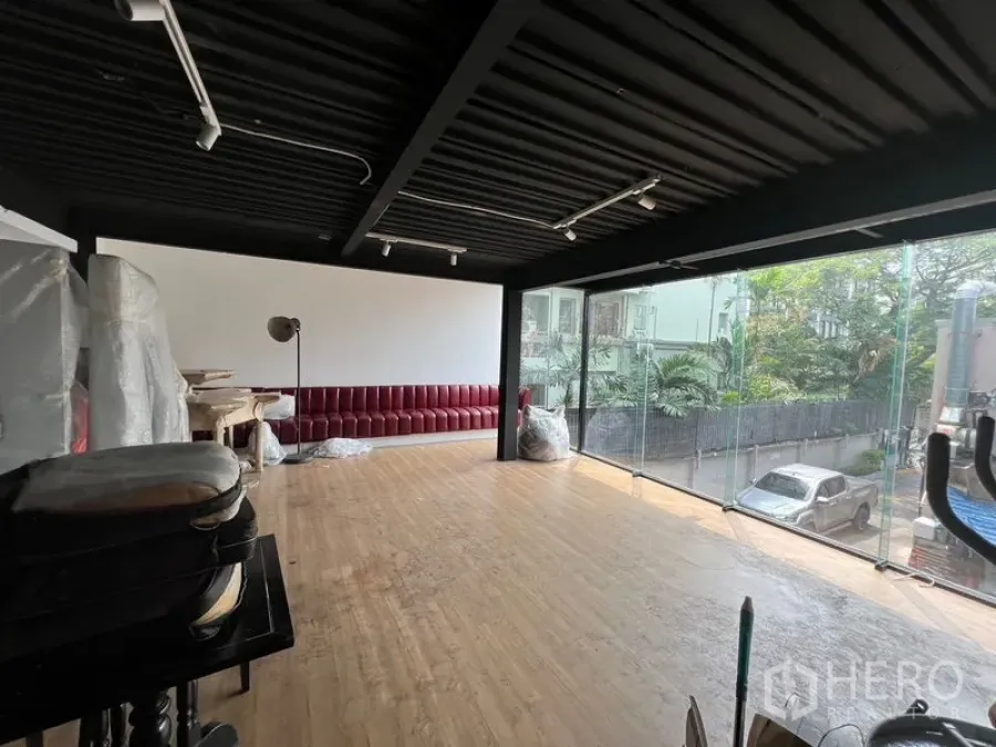 Retail Space for rent - Open retail showroom with panoramic glass frontage, wood floors, and an industrial black ceiling.