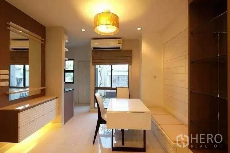 Townhouse for rent in Phra Khanong, Bangkok - Compact dining area with built-in bench seating, pendant lamp and window views.