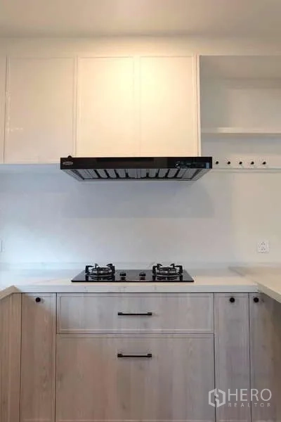 Detached House for rent in Bang Phli, Samut Prakan - Clean kitchenette with gas hob, range hood and white upper cabinets.