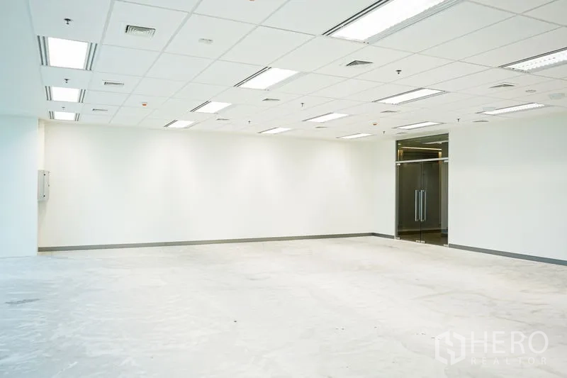 Office Space for rent in Bang Na, Bangkok - Open workspace with white walls, tiled ceiling and a glass double-door entry.