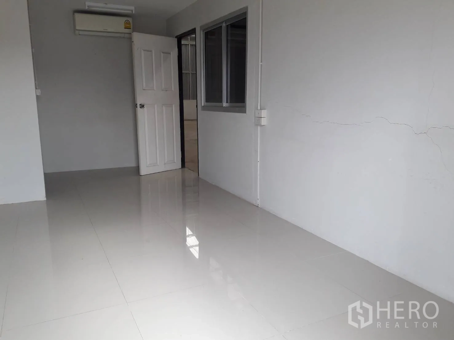 Warehouse for rent or sale in Khlong Luang, Pathum Thani - Air-conditioned office room with glossy tile flooring and a window overlooking the warehouse.