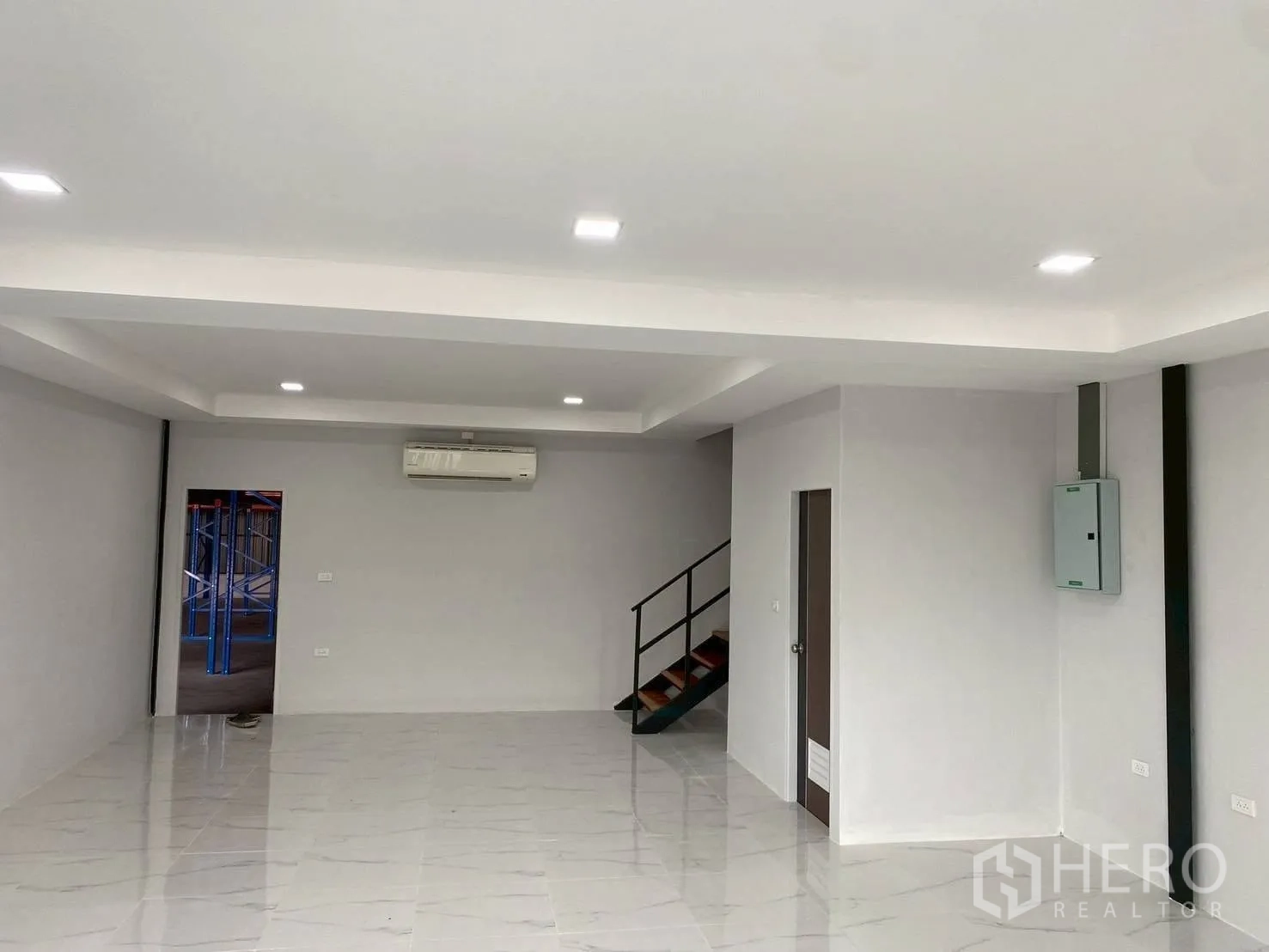 Warehouse for rent in Lam Luk Ka, Pathum Thani - Ground-floor office with tiled flooring, recessed lighting, air-conditioning, and stairs to the upper level.