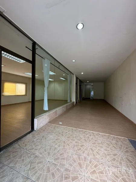 货栈 出租在Suan Luang, Bangkok - 一层走廊带玻璃隔断与地砖入口，适合做展厅通道。