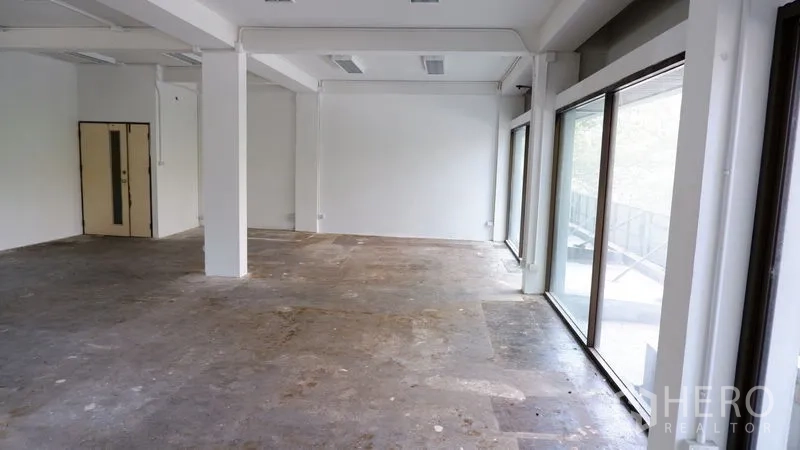 Office Space for rent in Watthana, Bangkok - Bright corner of the office with pillars and full-height glass on two sides.