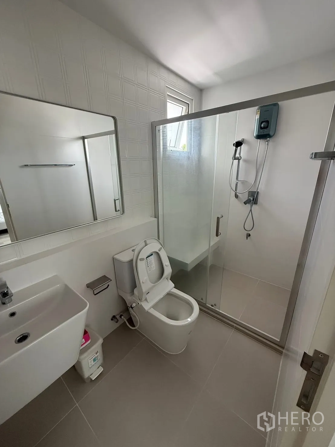 Detached House for rent in Bang Phli, Samut Prakan - Modern bathroom featuring a glass shower enclosure, toilet, sink, and water heater.