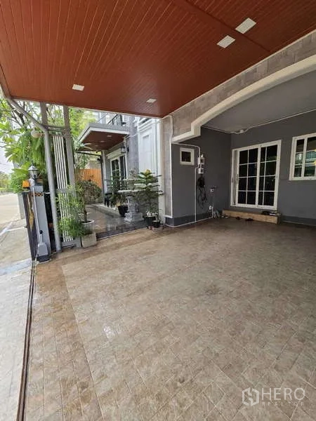 Detached House for rent in Thanyaburi, Pathum Thani - Spacious covered driveway with gate, tiled flooring and access to the main entrance.