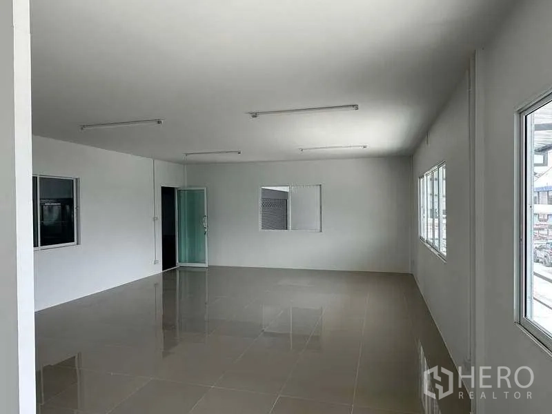 Warehouse for rent in Samut Prakan - Second‑floor office space with large windows, glossy tiles and fluorescent lighting.