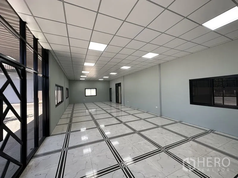 Factory for rent in Chachoengsao - Bright office space with grid ceiling, large windows and marble‑pattern floor tiles.