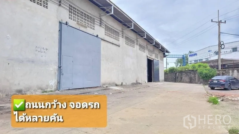 Warehouse for rent in Mueang Samut Sakhon, Samut Sakhon - Warehouse exterior in Mueang Samut Sakhon with large steel sliding door and wide access road for multiple parking.