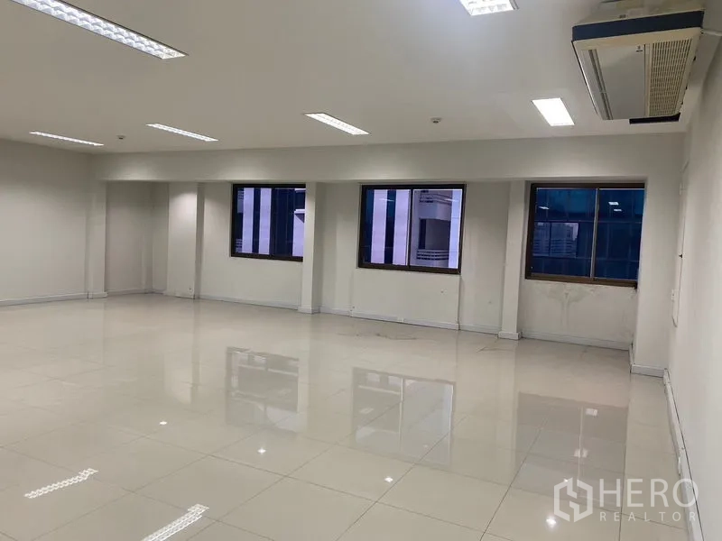Office Space for rent in Bang Na, Bangkok - Open office area with multiple windows, ceiling air-conditioning units and reflective flooring.