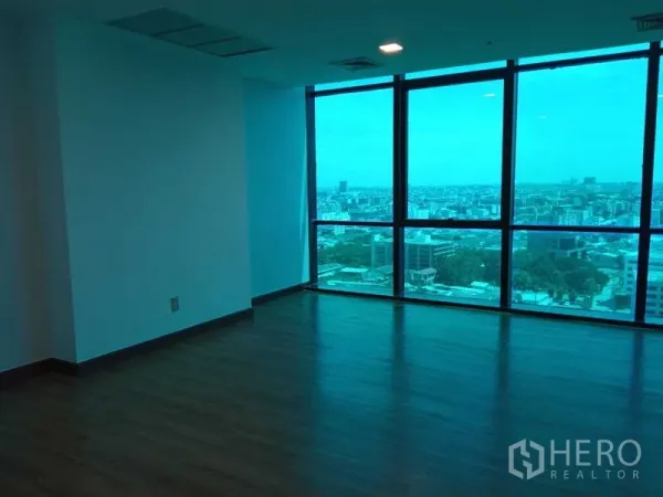 办公空间 出租在Din Daeng, Bangkok - 转角办公区，木地板，蓝色玻璃窗外宽阔城市景观