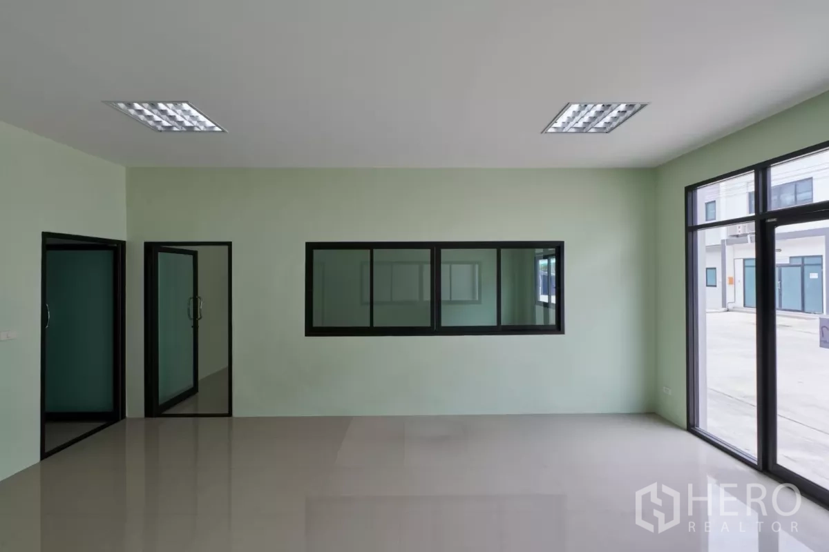 Factory for rent in Mueang Samut Sakhon, Samut Sakhon - Office interior with glass partitions and sliding windows linking to another room.