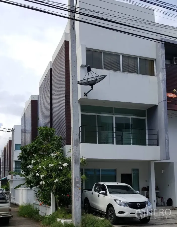 Condominium for rent in Pathum Wan, Bangkok - Modern townhouse-style building with glass frontage, balcony railings, a parked pickup truck and a satellite dish.