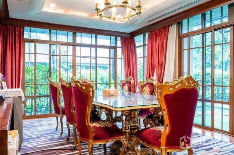 Detached House for rent in Khlong Toei, Bangkok - Formal dining room with chandelier, marble-top table and red upholstered chairs overlooking the pool.
