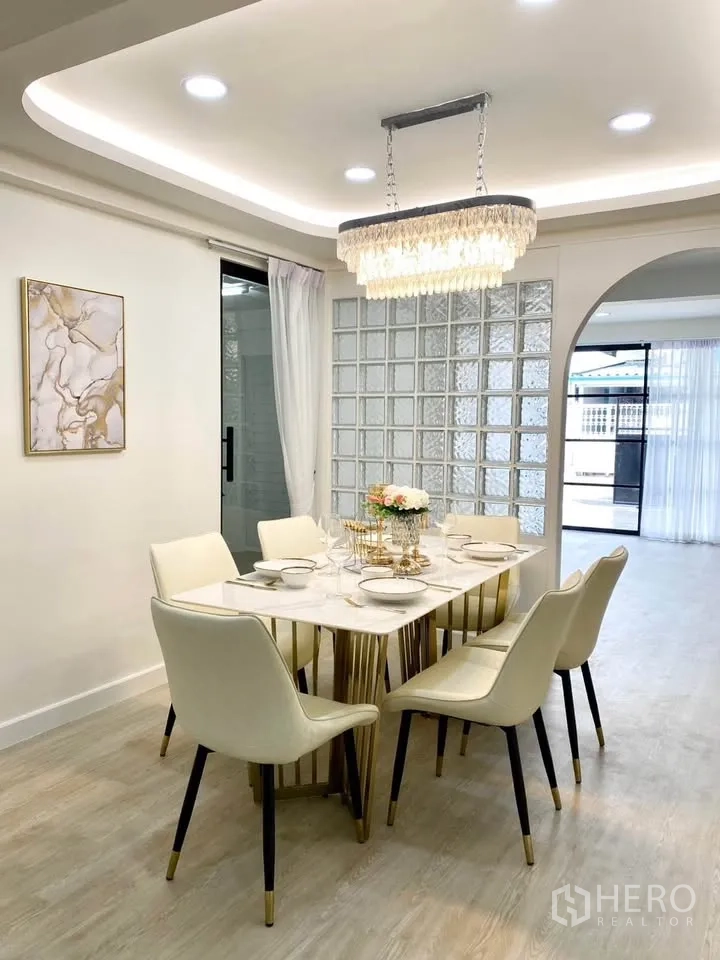 Detached House for rent in Huai Khwang, Bangkok - Dining room with marble-style table for six, chandelier and glass-block wall.
