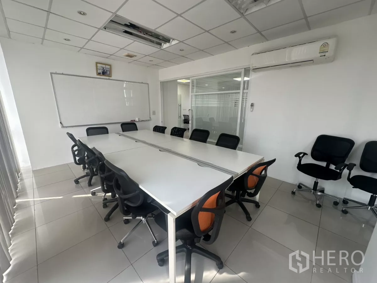 办公空间 出租在Huai Khwang, Bangkok - 配备长桌、多把椅子的会议室，带白板与挂壁空调。