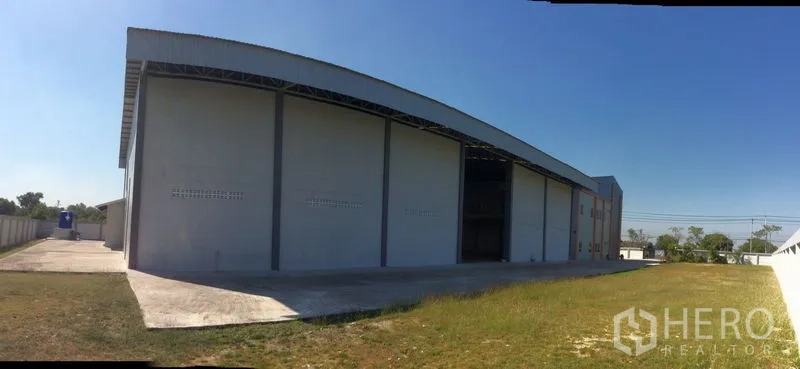 Factory for sale in Bang Sao Thong, Samut Prakan - Rear façade with ventilation blocks and a covered side walkway.