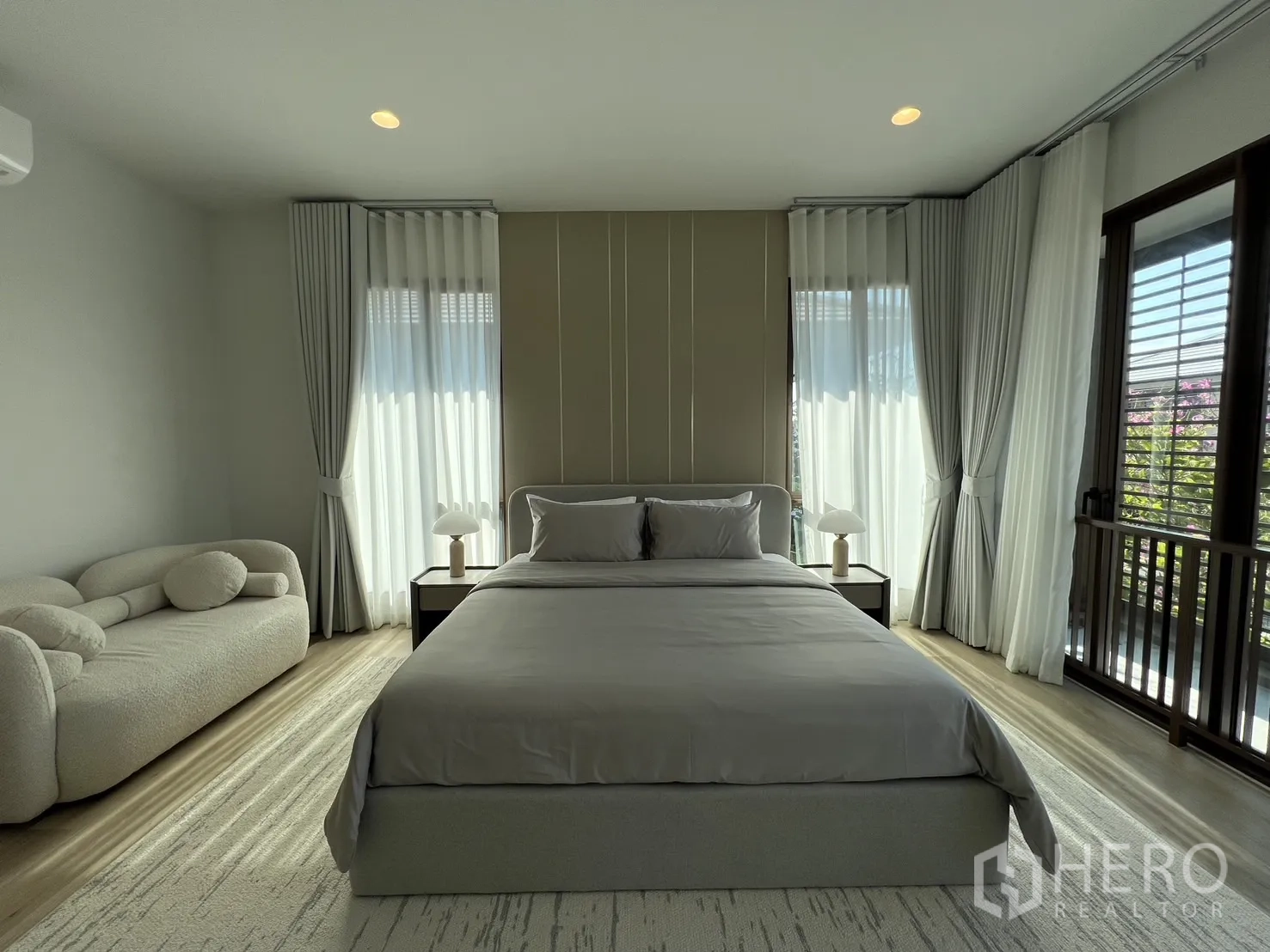 Detached House for rent or sale in Bang Kapi, Bangkok - Front view of king bed framed by windows and sheer drapes.