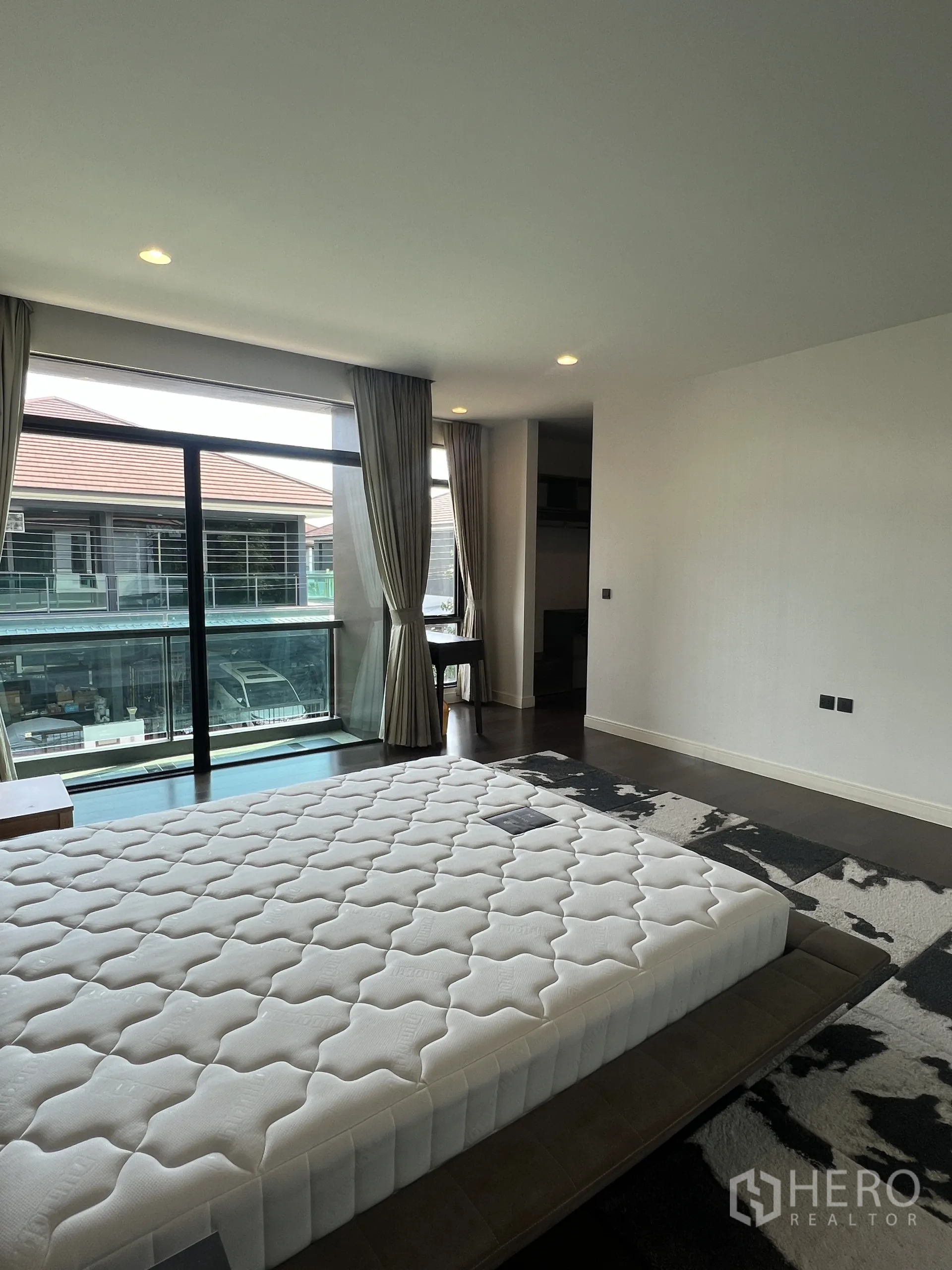 Detached House for rent in Bang Kapi, Bangkok - Walk-in closet with custom shelves, drawers and hanging rails in wood and gray tones.